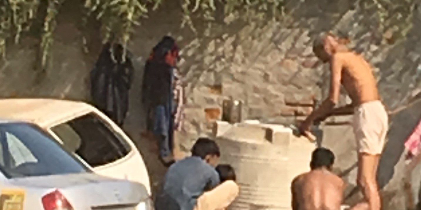 People bathing in a mud puddle in India
