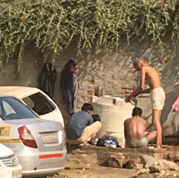 People bathing in a mud puddle in India