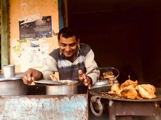Indian man serving samosa